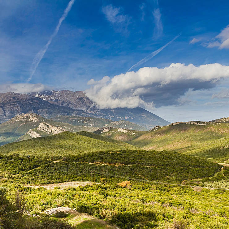 Panoramic view of Mount Parnassus with rolling green hills and dramatic clouds