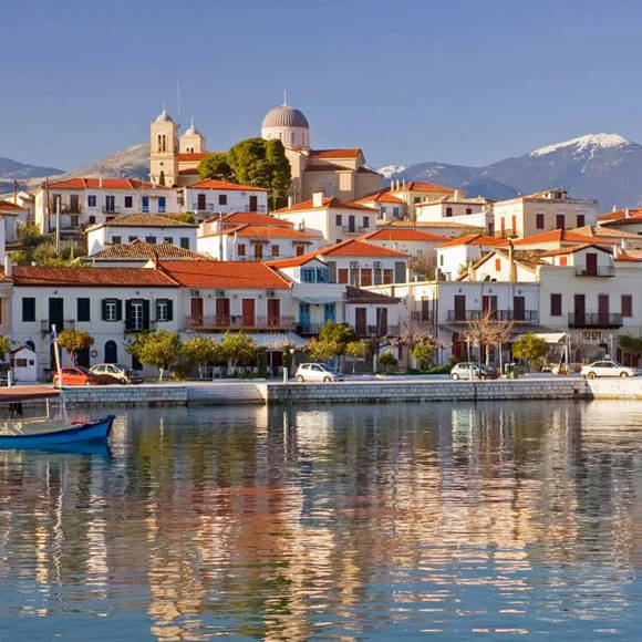 Seaside village of Galaxidi with colorful houses, small boats moored in the harbor and hills rising in the background
