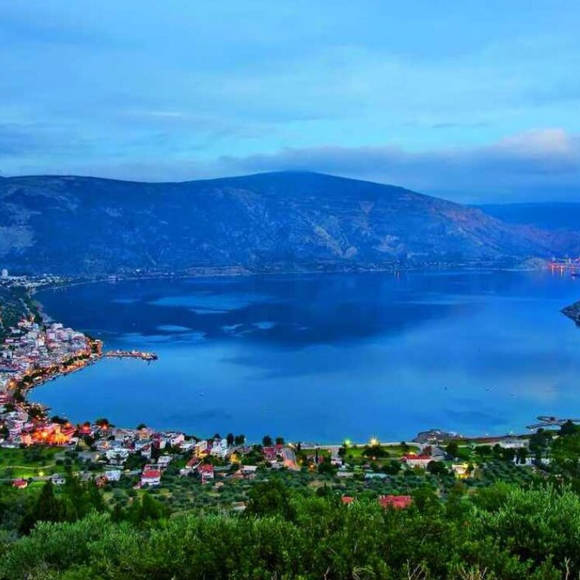 Panoramic view of Antikira bay surrounded by green hills and the seaside village below