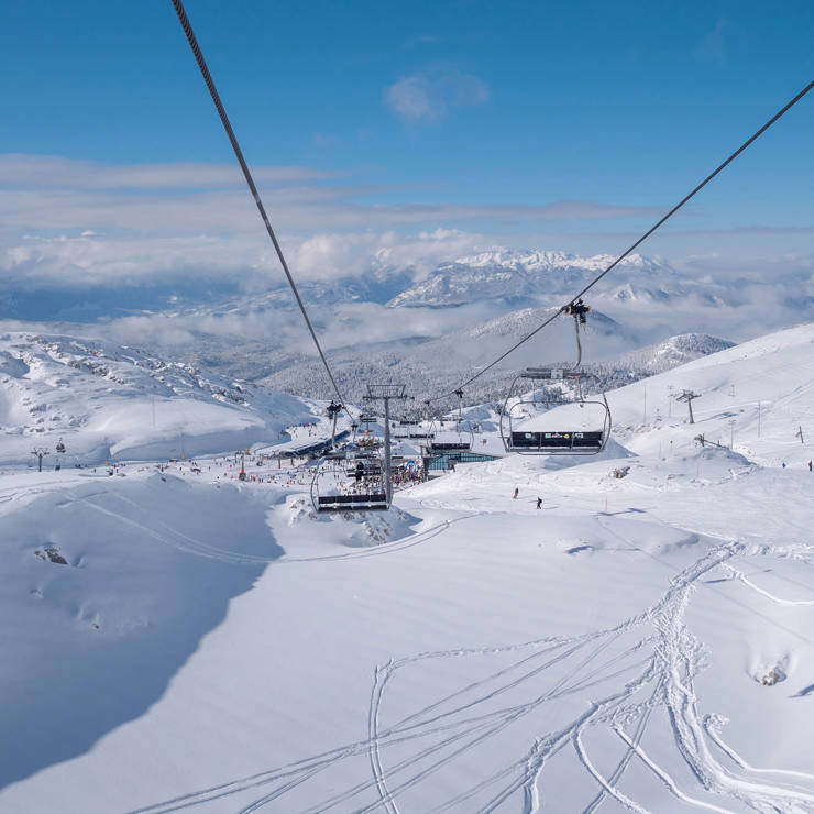 Snowy slopes and ski lifts at Mount Parnassus ski resort under a bright blue sky
