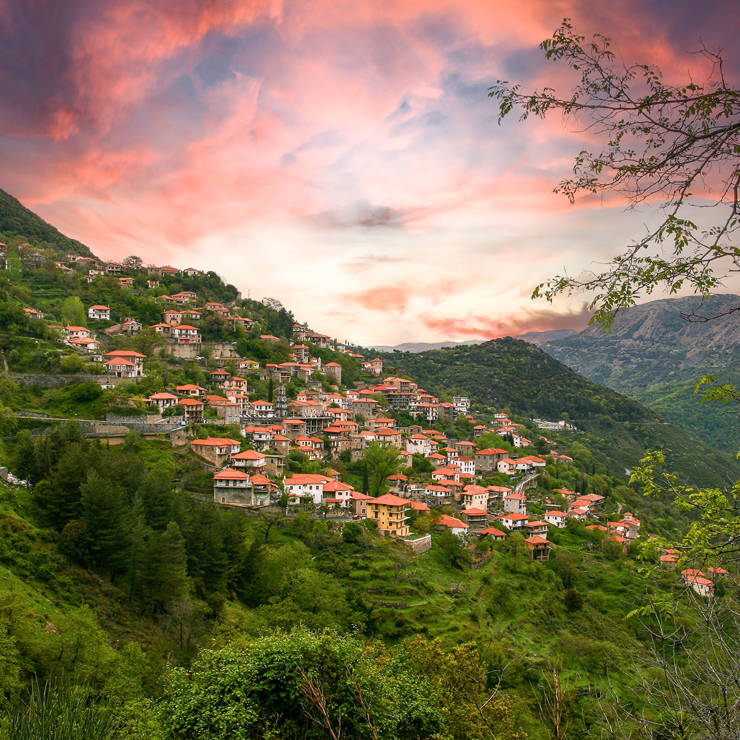 Scenic mountain village near Arachova surrounded by lush greenery at sunset