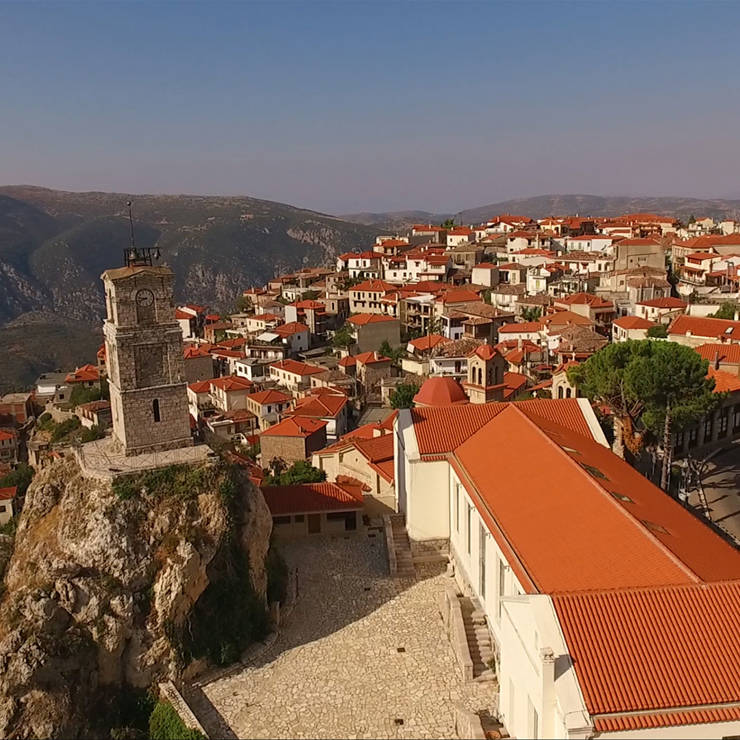 Aerial view of Arachova with its stone clock tower and red-tiled houses on the mountain slope